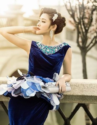 点击大图看下一张：新娘的蓝色妖姬连衣裙非常的妖艳，一款今年最流行的新娘盘发讲她的风姿韵味展现的淋漓尽致，这款新娘盘发是2013年最漂亮的，而且适合长脸新娘哦。