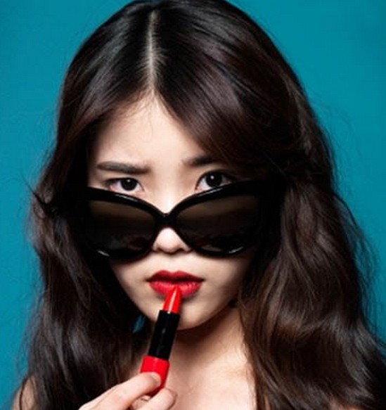 点击大图看下一张：俏皮御姐范的中长卷发发型，中分长刘海当中融入了时尚的复古红唇妆，搭配黑色墨镜，夸张眼神，性感而极具迷人魅力。