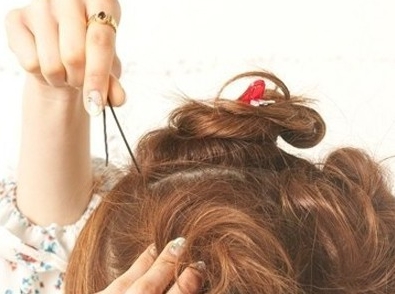 点击大图看下一张：韩式花苞头扎法步骤三：将刚好扎好的头发分别向上盘成一个圈，记住盘的时候要盘好，盘成花苞状哦，再用小夹子固定好。