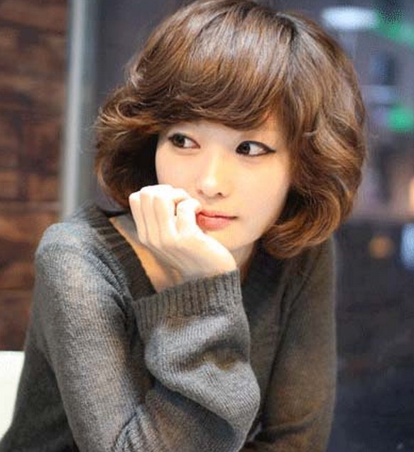 点击大图看下一张：这款韩系风的女生短卷发，斜刘海和两侧选择了蓬松的卷发弧度，看起来既是俏皮又不是时尚的个性感。