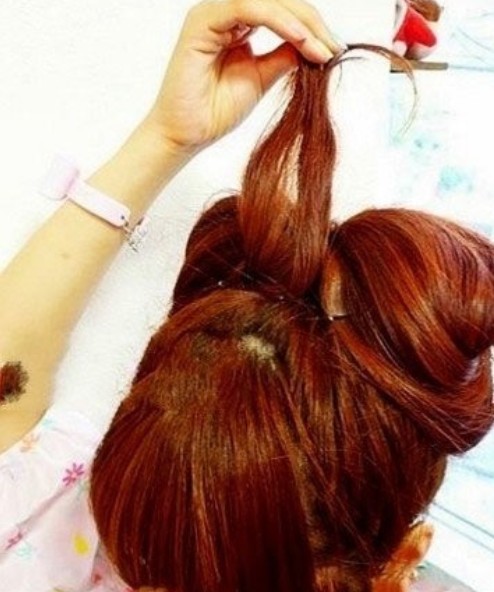 点击大图看下一张：韩式花苞头发型扎法步骤5、然后进入后面两发圈的根部，就会形成一个美美的蝴蝶结形状。这样发型的样子就出来了。