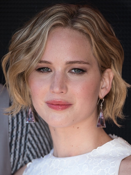 点击大图看下一张：Jennifer Lawrence示范把头发别到耳朵后的发型，小珍的俏丽短发上了微卷电棒后，轻轻的塞到耳后更迷人了！