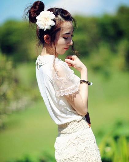 点击大图看下一张：唯美韩式丸子头，戴上一朵白色花朵的丸子头，这样的点缀非常有视觉上的美感，清新淡雅，留出来的两颊发丝，随风而起，又多了一种不可忽略的美艳。