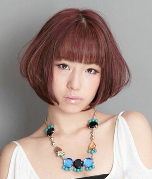 点击大图看下一张：此款日系女生短发烫发发型，蘑菇头的造型，蓬松的发丝，在视觉上修饰了脸型，棕红色的染发更具时尚感。