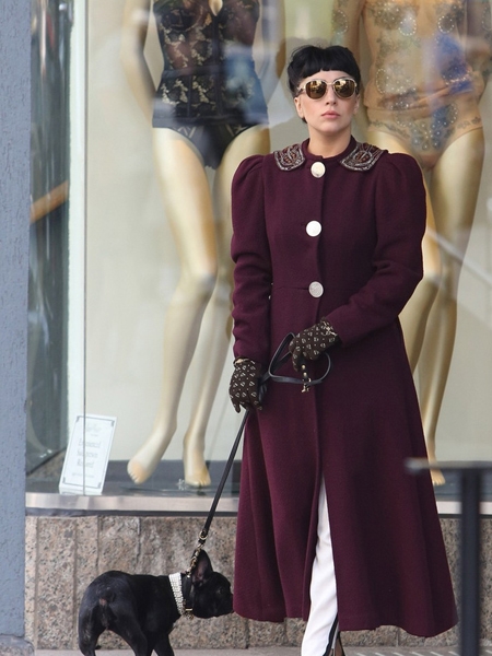 点击大图看下一张：Lady Gaga在加拿大多伦多得空出街，与母亲一同悠闲遛狗逛街，酒红色大衣和白色西服套装尽显复古风。这个锅盖刘海配上大墨镜却显得不再那么突兀。