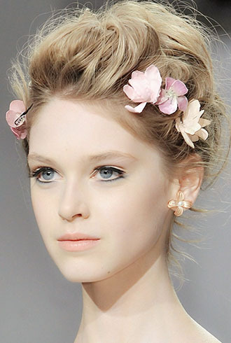 点击大图看下一张：秀场新娘发型图片一：蓬松立体的蜂窝盘发，配上花朵装饰，透出迷人仙气。