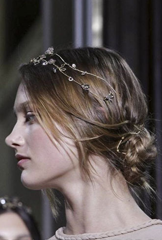 点击大图看下一张：秀场新娘发型图片二：头发被随意松散的盘成麻花发髻，再佩戴上宛如橄榄枝般仙美的宝石头饰，浪漫唯美。