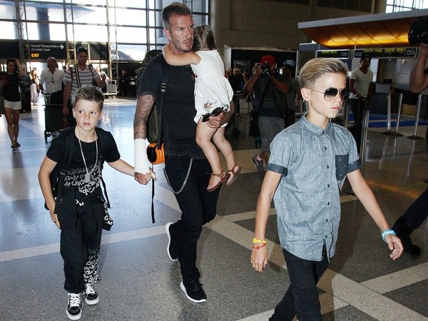 点击大图看下一张：大卫贝克汉姆戴着一对儿子和小女儿现身机场，苹果妹两根辫子，复古又可爱，两个儿子也是潮范十足。