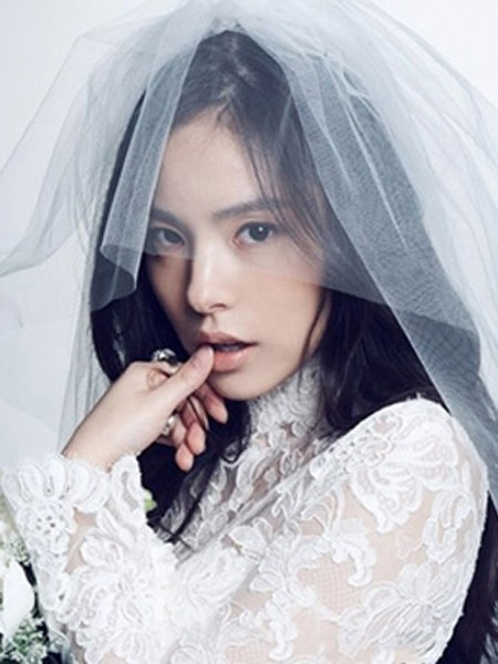 点击大图看下一张：适合喜欢简约风的准新娘打造的新娘发型设计，偏分的韩式盘发简洁大方，搭配长长的头纱和婚纱，清新脱俗的新娘造型。