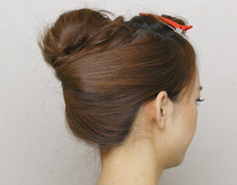 点击大图看下一张：步骤五：将两边的头发分别包裹住脑后的发簪内扭转起来。