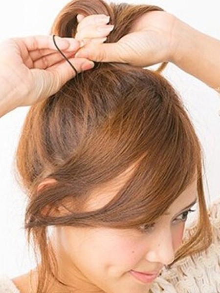 点击大图看下一张：STEP1：把头发高高扎起马尾，耳朵两边留下两小缕卷发垂落在脸颊两边。