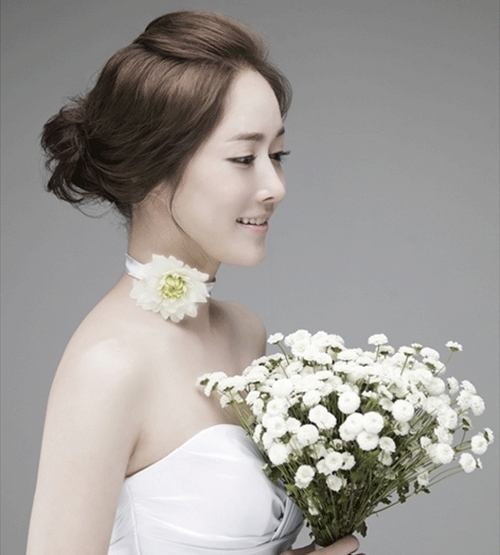 点击大图看下一张：这款韩式新娘盘发甜美优雅，前面的头发弄到后面，很好的展现了你完美的脸型哦，后面随意自然略显凌乱的盘发看起来也很好看哦。