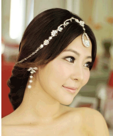 点击大图看下一张：一款很甜美优雅的韩式新娘盘发哦，中分不仅显得有点妩媚还可以修饰脸型哦，而且头上的链条装饰看起来也美极了，特别是额前的那颗大大的钻石模样的东西，太美了。