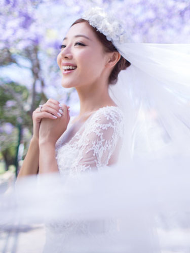 点击大图看下一张：邓家佳一身洁白婚纱，头顶花状头纱，造型似仙女，脸上洋溢着幸福的微笑。