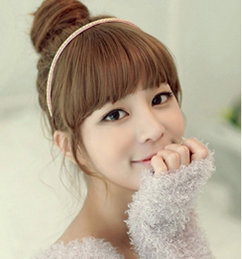点击大图看下一张：简单韩式丸子头九：这款唯美感丸子头是典型的韩式发型，齐刘海很好的修饰了脸型，配上可爱的发饰，显得甜美、清秀。