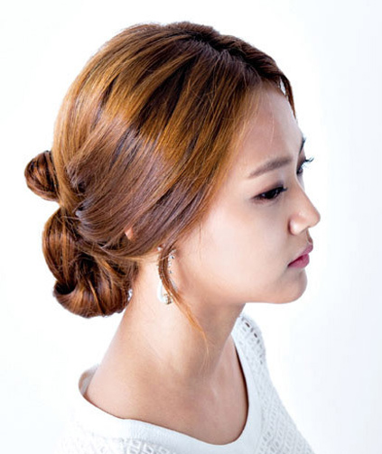 点击大图看下一张：最新韩国女生发型七：中分长发随意的盘成一个花苞头，细碎的刘海摆动在耳际，女人味十足。