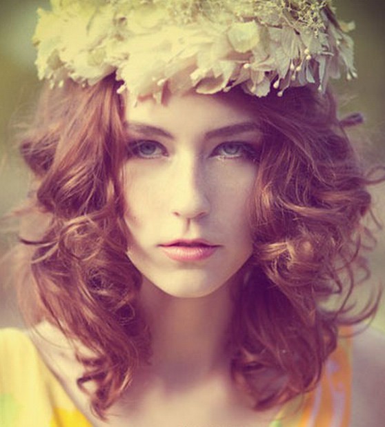 点击大图看下一张：浪漫唯美的短卷女生发型，顶部的一个白色花环作点缀，恰好带出完美的希腊女神感觉，动感蓬松的卷发设计，也起到了优雅甜美气质哦！