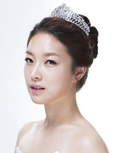 点击大图看下一张：精美韩式新娘盘发：高贵、优雅的皇冠装饰，简单盘起来的头发，最后固定上的精美皇冠发饰，抹胸的婚纱搭配，优雅美丽的新娘出现。