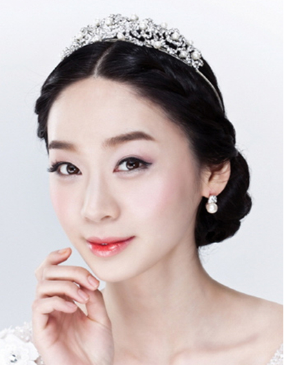 点击大图看下一张：中分韩式新娘盘发：中分的刘海编发，很好展现出新娘精致脸蛋，配戴上精致美观的皇冠发饰，整款发型都变得完美无比。