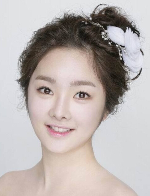 点击大图看下一张：给人一种梦幻感的韩式新娘盘发发型，梳起在一侧的刘海，做出了造型，让新娘的脸型愈发精致动人。
