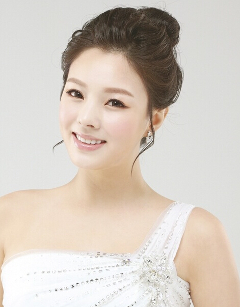 点击大图看下一张：很简单的一款韩式新娘盘发发型，经典雅致的高发髻，赋予新娘女王般尊贵的气质，斜肩的婚纱更衬出了别样的高贵感。