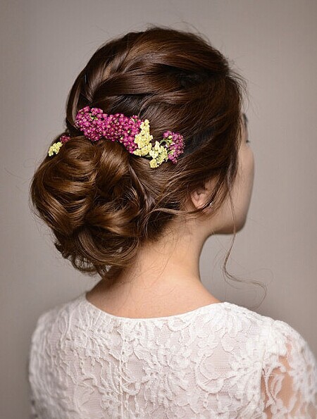 点击大图看下一张：十分流行的韩式新娘盘发，当花苞发髻结合编发设计，给人很好的温婉魅力，花朵发饰的点缀后，又是几分清新浪漫美感。