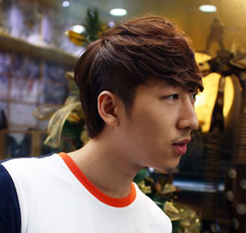 点击大图看下一张：韩式男生卷发发型设计二：厚重的刘海，很好的修饰了长脸脸型，红棕色的染发颜色，整体造型，更好的突出了男生的成熟魅力。