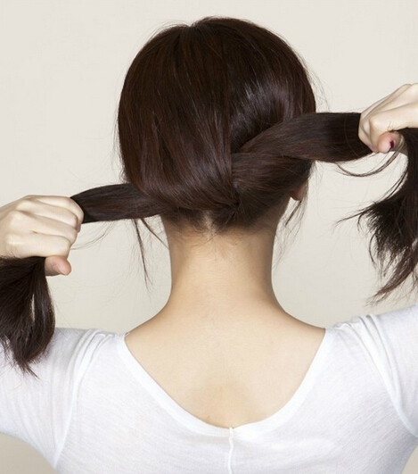 点击大图看下一张：第二步、将头发梳理好之后，再从后面将头发分成2部分，然后拿起两束头发打一个结，打结的时候注意一下，头发不要弄得太乱；
