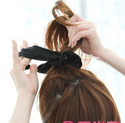 点击大图看下一张：步骤二：首先使用橡皮筋把梳起来的头发扎起来，形成一个高扎的马尾辫，然后是在外面缠上一个比较粗的发圈。