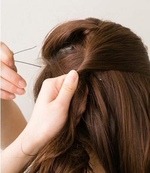 点击大图看下一张：步骤四：再从右侧取出一束头发扭转后拉扯到左侧用发夹固定。