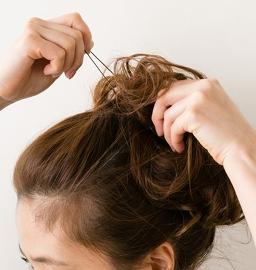 点击大图看下一张：步骤七：将脑后的头发绑在头顶扭转成蓬松造型并用发夹固定。