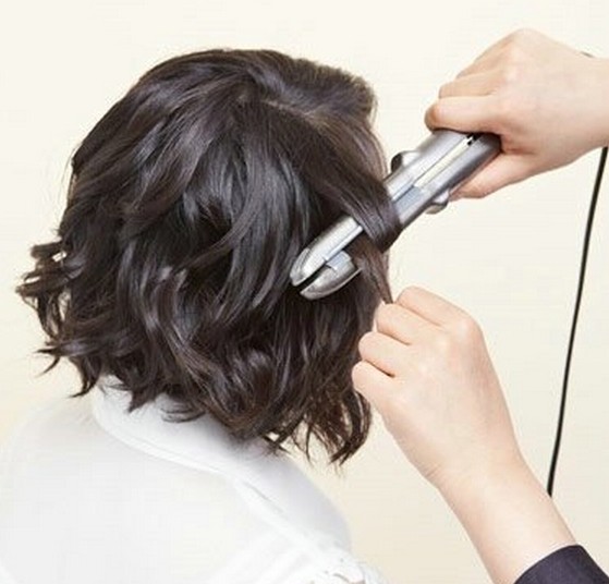 点击大图看下一张：1、先是把短发分部分放在卷发棒上，然后进行烫卷效果。