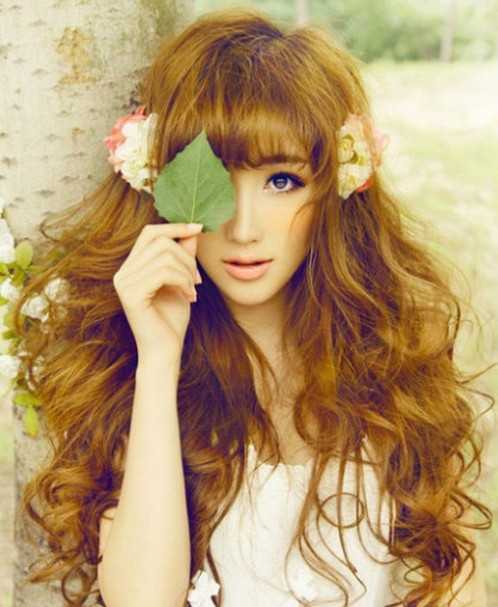 点击大图看下一张：比较流行的一款日本女生发型，蓬松的大波浪卷发看起来个性时尚十足，内扣的齐刘海，在花朵发饰的装点下， 更是清新唯美感。