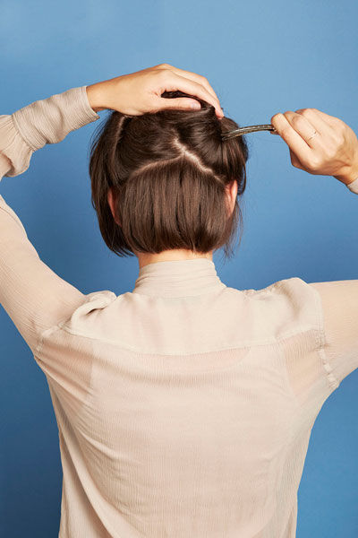 点击大图看下一张：先用尖尾梳仔细梳理每一寸头发，目的是增加一些凌乱的纹理，而且越松散越好，会有利于后面的造型。把脑后的头发分成4个部分，将其中正后方的部分夹起来。