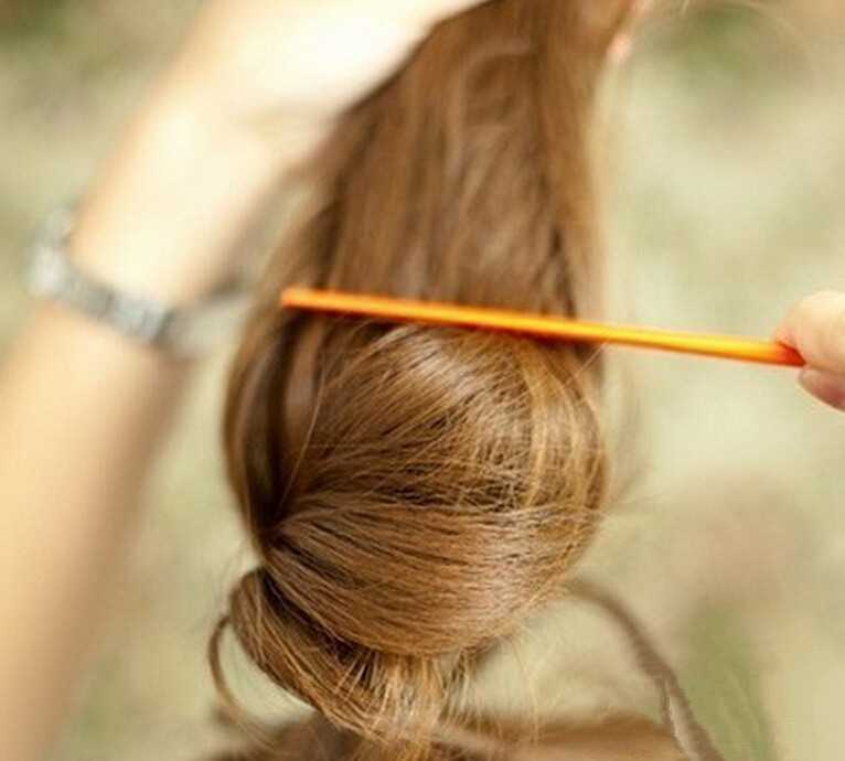 点击大图看下一张：步骤二：把扎好的头发倒拿起来，用梳子梳蓬松，要让头发保持足够的蓬松感哦。
