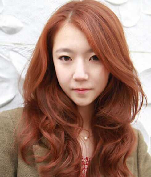点击大图看下一张：韩系风的女生发型图，波浪式的卷烫发，彰显知性女人味，弧度外翻的大侧分刘海，又是御姐范尽显，亮丽的红棕发色，足够时尚个性。