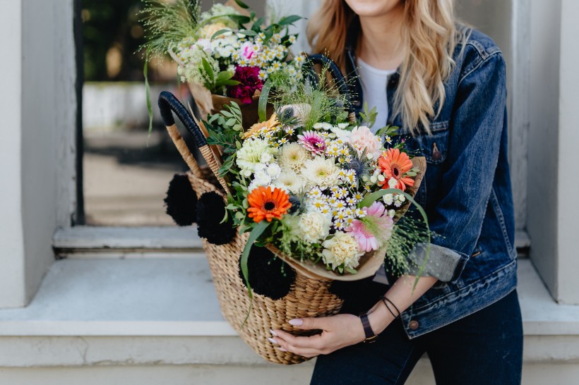 点击大图看下一张：女孩提着装满鲜花的篮子图片
