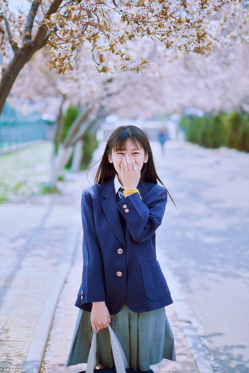 点击大图看下一张：樱花之下的清纯制服日系学生妹甜美的笑容