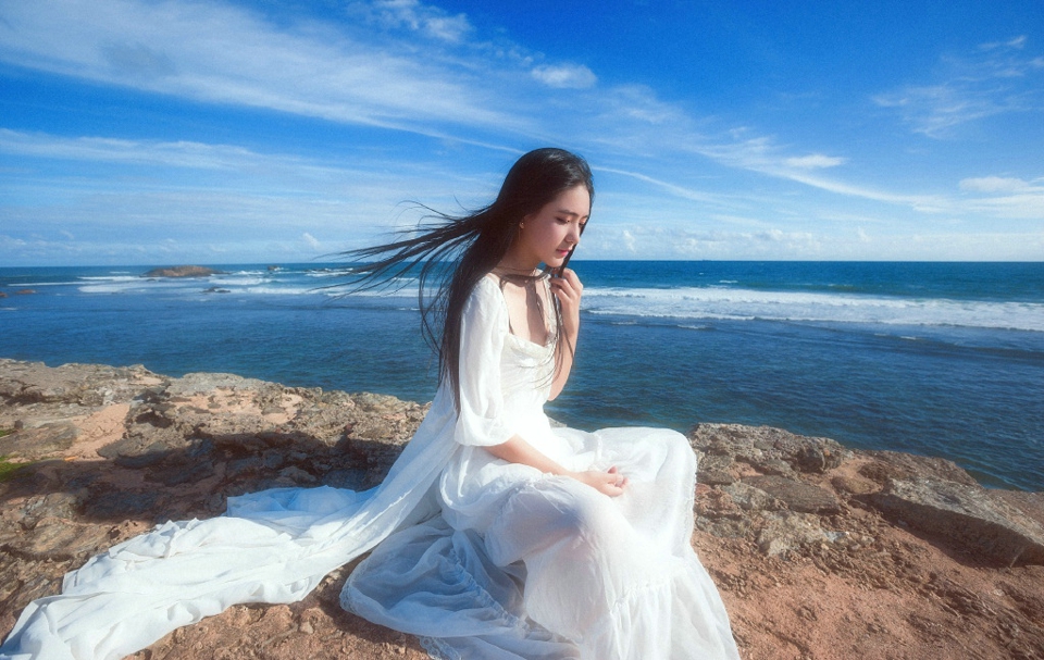 点击大图看下一张：海岛上的白裙气质女神海风秀发飘逸