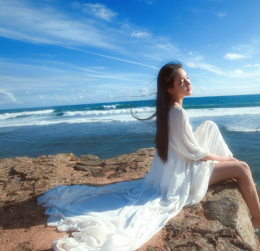 点击大图看下一张：海岛上的白裙气质女神海风秀发飘逸
