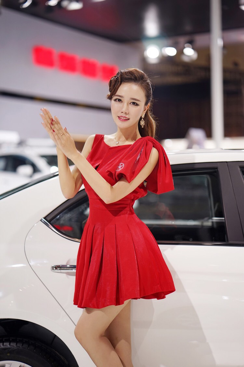 点击大图看下一张：红裙长腿车模白皙肌肤魅力无限