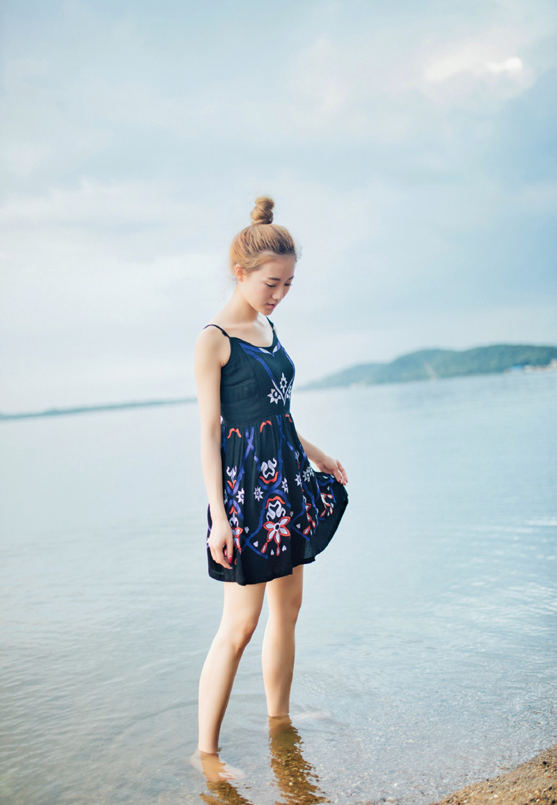点击大图看下一张：丸子头少女吊带裙海边清凉写真