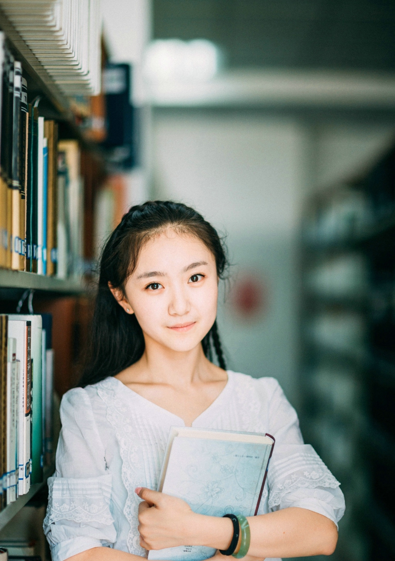 点击大图看下一张：图书馆内的素颜笑容可爱少女