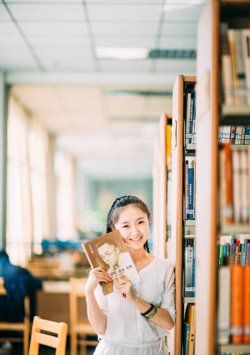点击大图看下一张：图书馆内的素颜笑容可爱少女