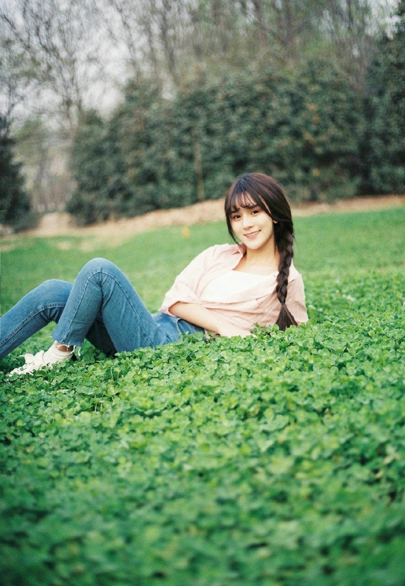 点击大图看下一张：麻花辫甜美少女草地上清新微笑