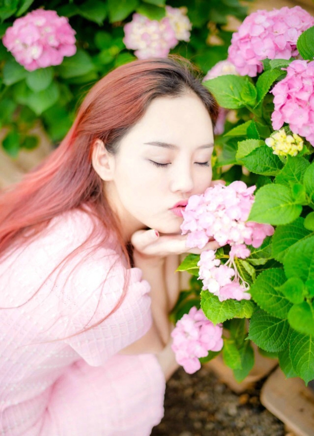 点击大图看下一张：绣球花丛中的红发美女花香四溢