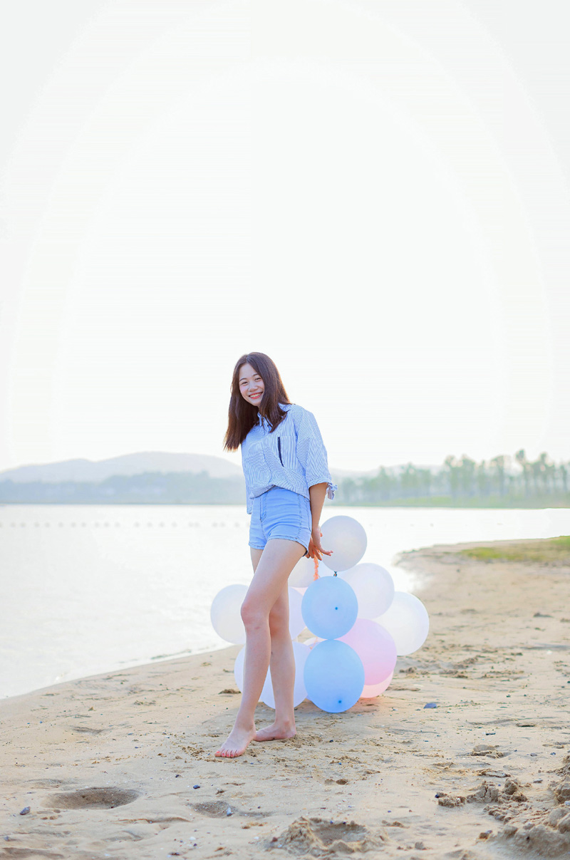 点击大图看下一张：气球少女海边沙滩跳跃写真青春活力