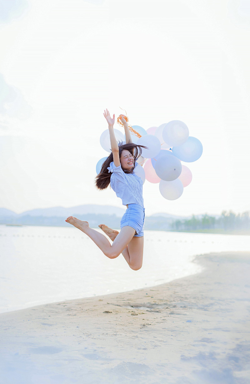 点击大图看下一张：气球少女海边沙滩跳跃写真青春活力