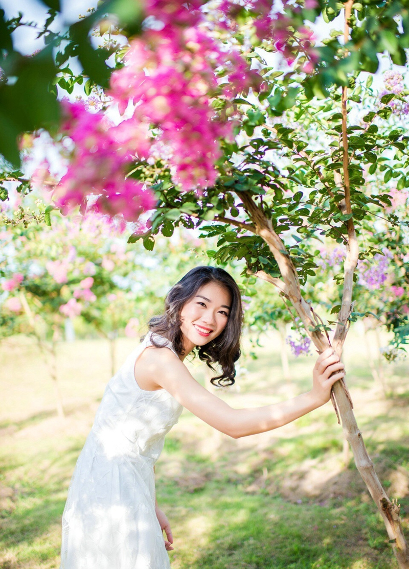 点击大图看下一张：花树下的漂亮美女笑容灿烂阳光