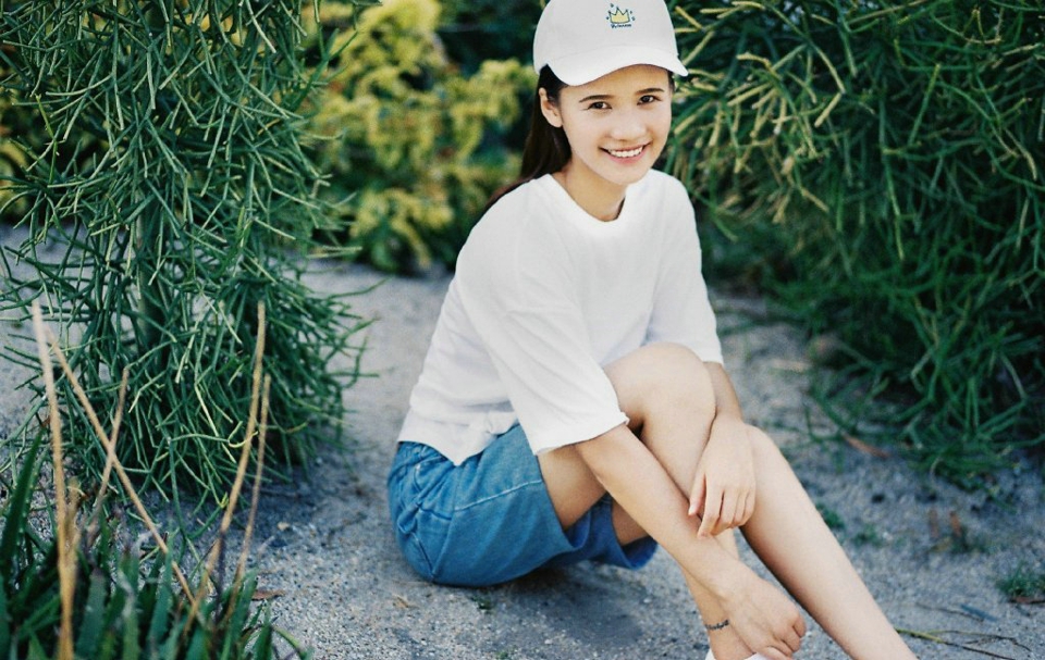 点击大图看下一张：植物园内的棒球帽美女休闲阳光笑容
